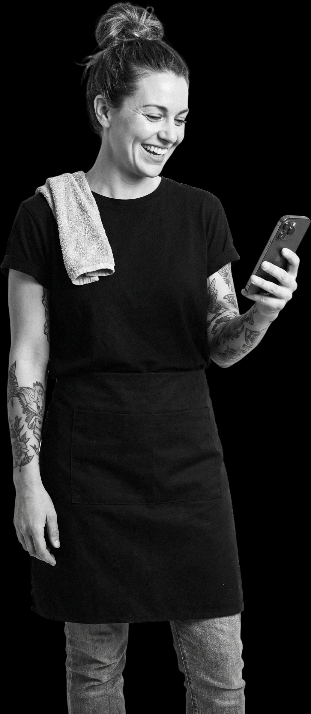 A café owner laughing at a message on her phone